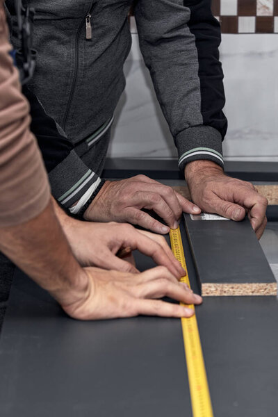 Мастер по изготовлению кухонных шкафов в квартире.