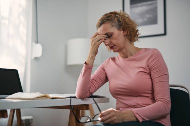 Gözleri ağrıyan bir kadın, sinüs sorunu, baş ağrısı, baş ağrısı, ev sorunları ve sorunlarıyla uğraşan bir kadın..