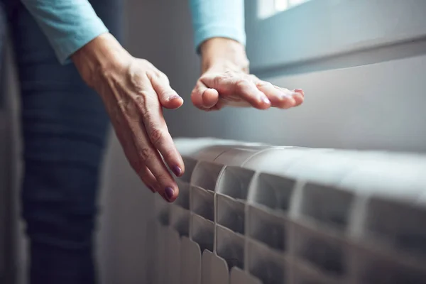 Женщина Нагревает Руки Радиаторе Холодные Зимние Дни — стоковое фото