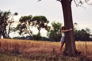 Doğada sarılan ve kucaklayan bir kadın.