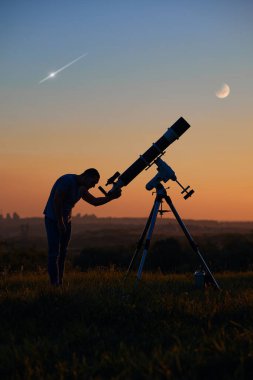 Bir adamın silueti, astronomik teleskop, kırsal alan, ay tutulması ve meteor yağmuru..