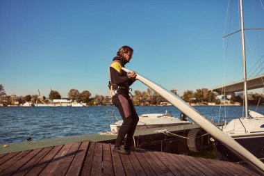Rüzgar sörfçüsü nehirde rüzgarlı bir günde sörf yapıyor..