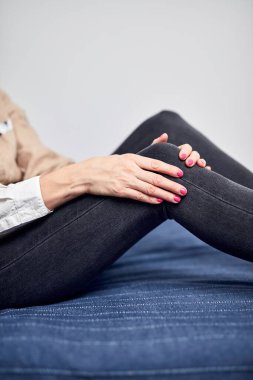 Kasılma, kramp, burkulma, çıkık diz, yırtık tendon ve eklem ağrısı olan bir kadın, evde yatağında yatıyor..