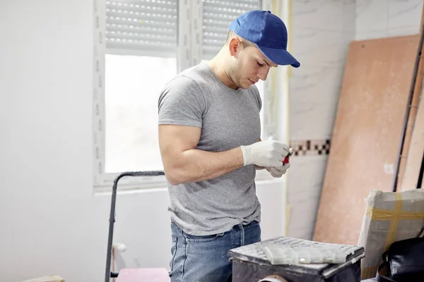 一个年轻的成年人正在粉刷他的新居公寓 并在装修他的Diy预算 — 图库照片