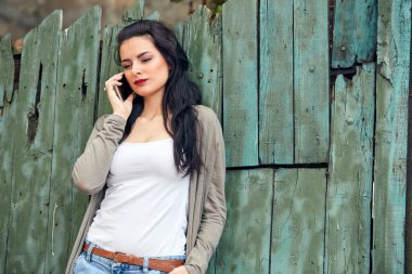 Sokakta smatrphone kullanan genç ve tatlı bir kadın..