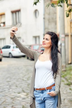 Sokakta smatrphone kullanan genç ve tatlı bir kadın..