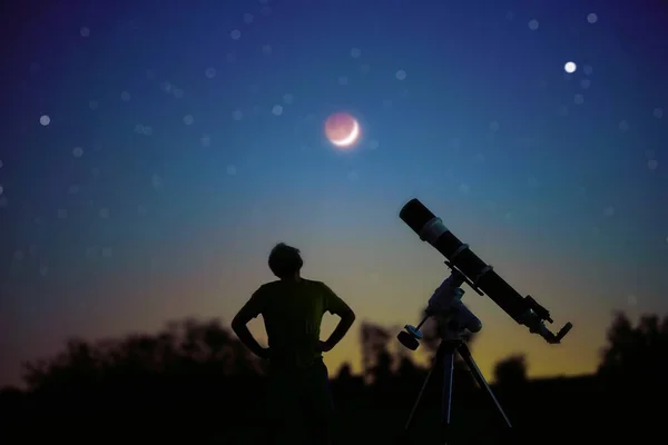 一个人的轮廓 望远镜和乡村在星空下与年轻的月亮 — 图库照片