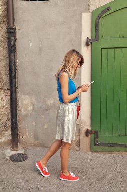 Sokakta smatrphone kullanan genç ve tatlı bir kadın..