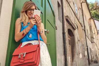 Sokakta smatrphone kullanan genç ve tatlı bir kadın..