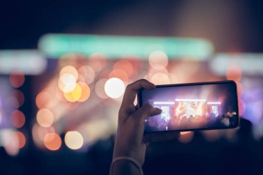 Konserde elinde modern akıllı telefon tutan biri..