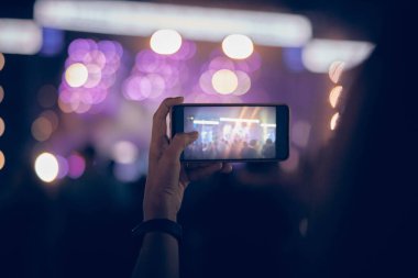 Konserde elinde modern akıllı telefon tutan biri..