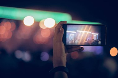 Konserde elinde modern akıllı telefon tutan biri..