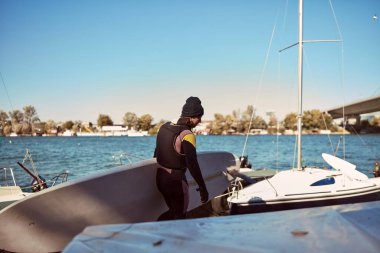 Rüzgar sörfçüsü nehirde rüzgarlı bir günde sörf yapıyor..