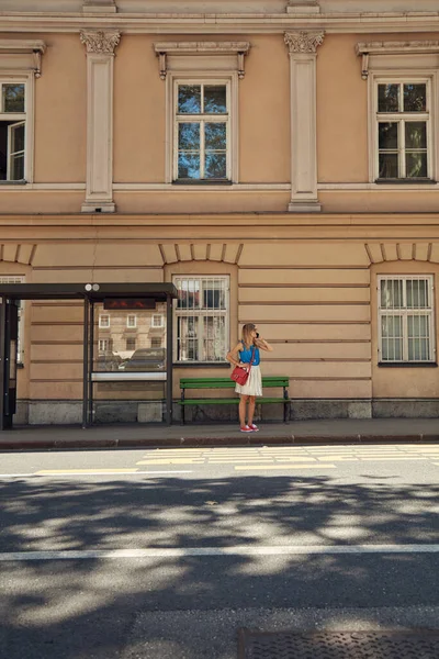 Beyaz bir kadın istasyonda toplu taşıma için bekliyor..