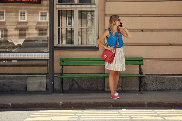 Beyaz bir kadın istasyonda toplu taşıma için bekliyor..