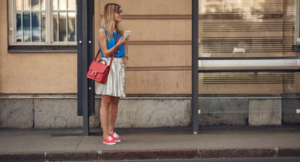 Beyaz bir kadın istasyonda toplu taşıma için bekliyor..