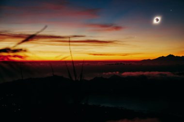 Renkli bir gökyüzünde güneş tutulması.