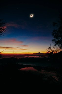 Renkli bir gökyüzünde güneş tutulması.