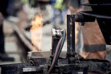 Çelik tren rayları için makine kullanan inşaat işçisi.