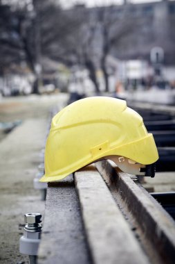 Construction protective helmet on a steel railway track.