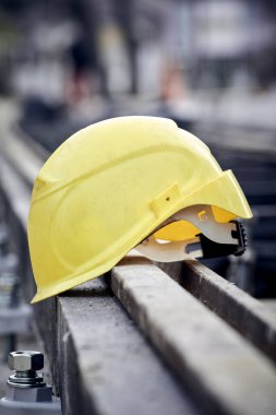 Construction protective helmet on a steel railway track.