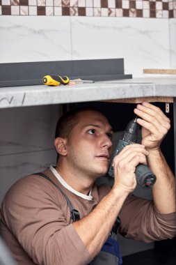 Tamirci dairede mutfak dolabı yapıyor..