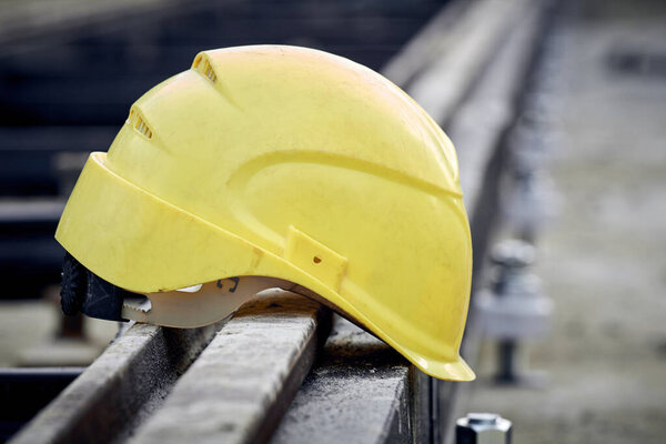 Construction protective helmet on a steel railway track.