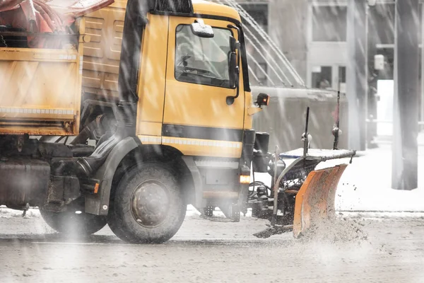 Snow plow truck cleaning streets from heavy snowfall.