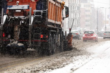 Kar küreme kamyonu sokakları yoğun kar yağışından temizliyor.