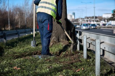 Sokak çimlerini koruyan üniformalı bir işçi..