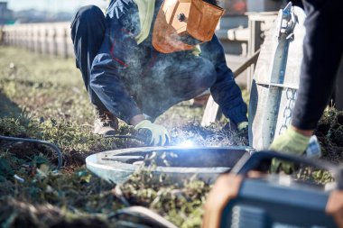Kaynakçı kanalizasyon kapağı üzerinde çalışıyor..