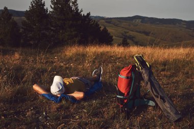 Doğada kamp yapan, küçük çadırları açan ve paketleyen, dinlenme ve hobileri olan bir adam..
