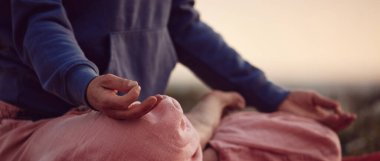 Gün batımında dışarıda yoga yapan bir kadın..