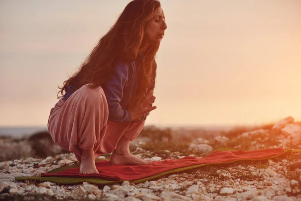 日落时分在户外练瑜伽的女人 — 图库照片