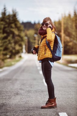 Kırsal yolun ortasında eğlenen genç bir kadın..