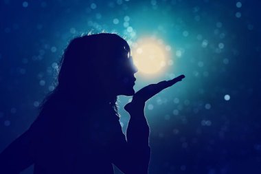 Yıldızların altında eğlenen kadın, okyanus sularının üzerinde ay ışığı olan gece..
