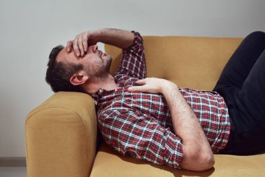 Başı ağrıyan bir adam evde.