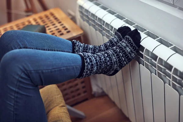 寒い冬の日に足を加熱する女性 エネルギーとガス危機 寒い部屋 暖房の問題 — ストック写真