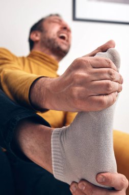 Ayak ağrısı, çıkık, uyuşukluk, kramp ve diğer eklem sorunları olan yetişkin bir erkek..