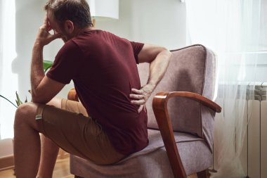Sırt ağrısı ve bel fıtığı olan bir adam..