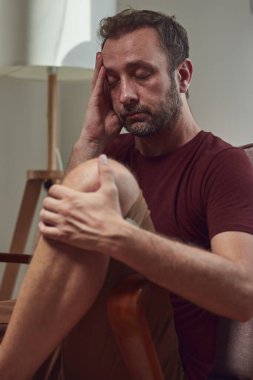 Başı ağrıyan bir adam evde oturuyor..