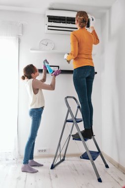 Anne ve kızı evdeki havalandırma filtrelerini temizliyor..