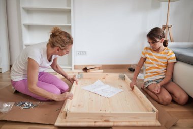 Anne ve kızı yeni bir eve taşınmak için yeni mobilya monte ediyorlar..