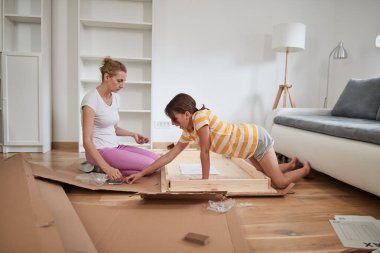 Anne ve kızı yeni bir eve taşınmak için yeni mobilya monte ediyorlar..