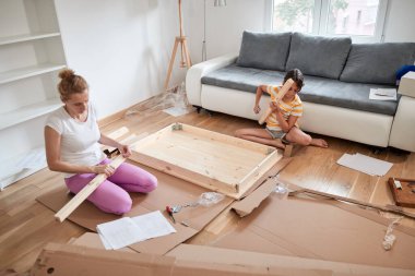 Anne ve kızı yeni bir eve taşınmak için yeni mobilya monte ediyorlar..