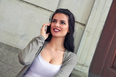 Sokakta akıllı telefon kullanan hoş bir bayan..