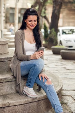 Sokakta akıllı telefon kullanan hoş bir bayan..