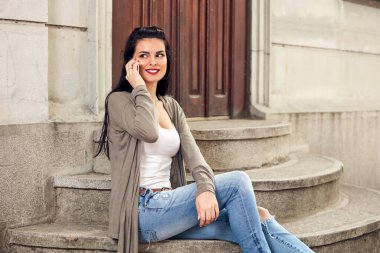 Sokakta akıllı telefon kullanan hoş bir bayan..