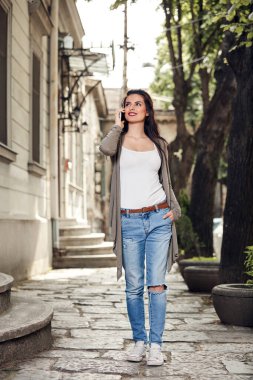 Sokakta akıllı telefon kullanan hoş bir bayan..