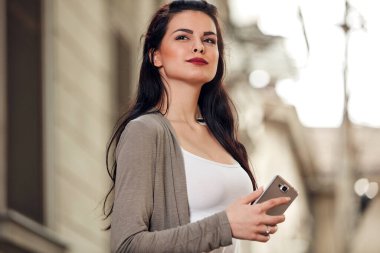 Sokakta akıllı telefon kullanan hoş bir bayan..